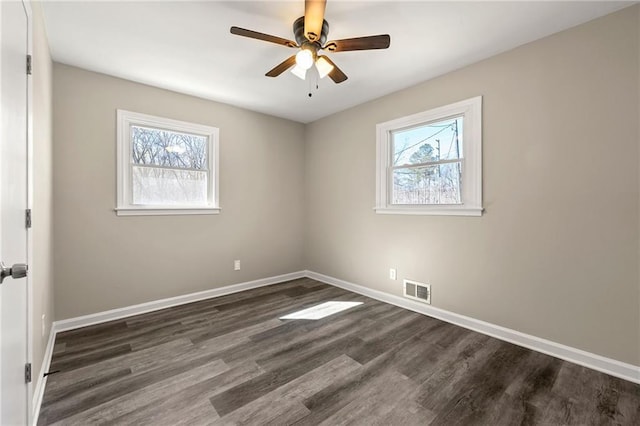 unfurnished bedroom with multiple windows, wood finished floors, visible vents, and baseboards