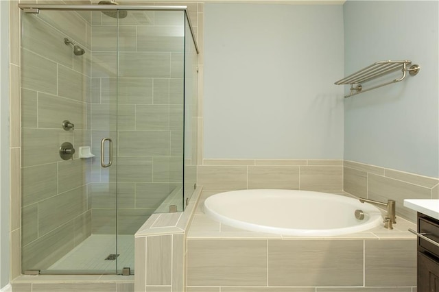 bathroom featuring vanity, a stall shower, and a bath