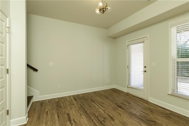 spare room featuring dark wood-style flooring, baseboards, and a wealth of natural light