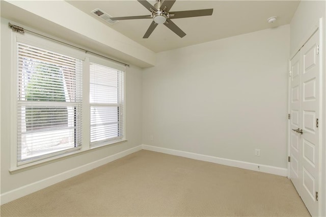 spare room featuring visible vents, baseboards, and light carpet