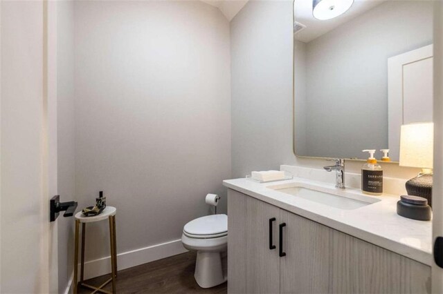 bathroom featuring hardwood / wood-style flooring, vanity, and toilet