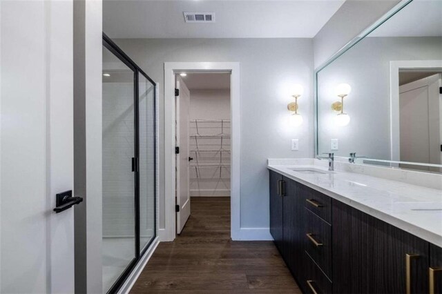 bathroom featuring hardwood / wood-style floors, vanity, and an enclosed shower