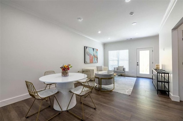 dining space with crown molding and dark hardwood / wood-style floors