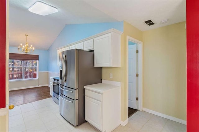 kitchen with an inviting chandelier, light hardwood / wood-style floors, vaulted ceiling, white cabinets, and appliances with stainless steel finishes