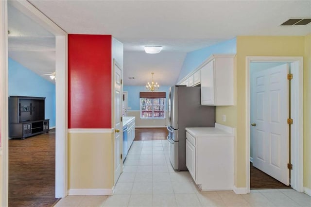 kitchen with white cabinets, lofted ceiling, and light tile patterned flooring