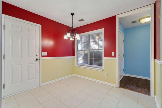 unfurnished dining area with a chandelier