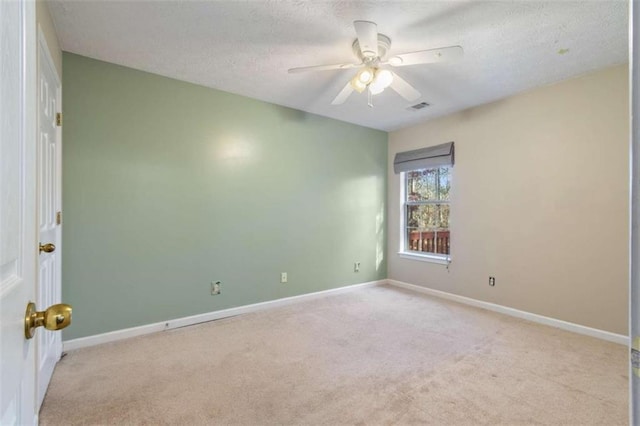 unfurnished room with a textured ceiling, ceiling fan, and light carpet