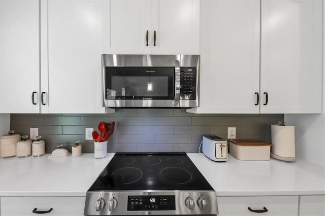 kitchen with white cabinetry, tasteful backsplash, and stainless steel appliances