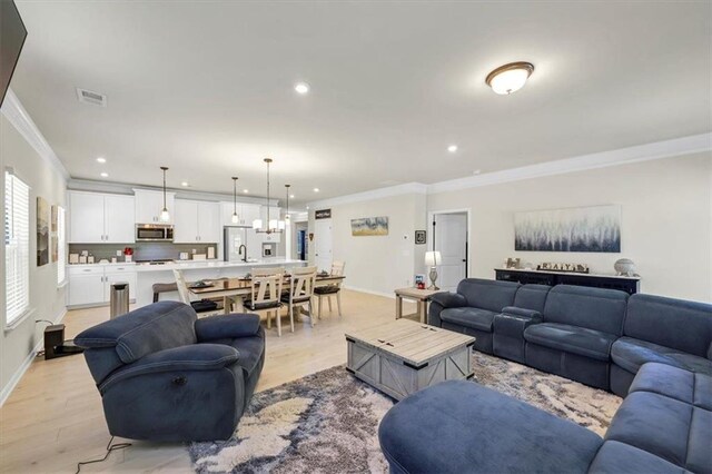 living room featuring crown molding and light wood-type flooring