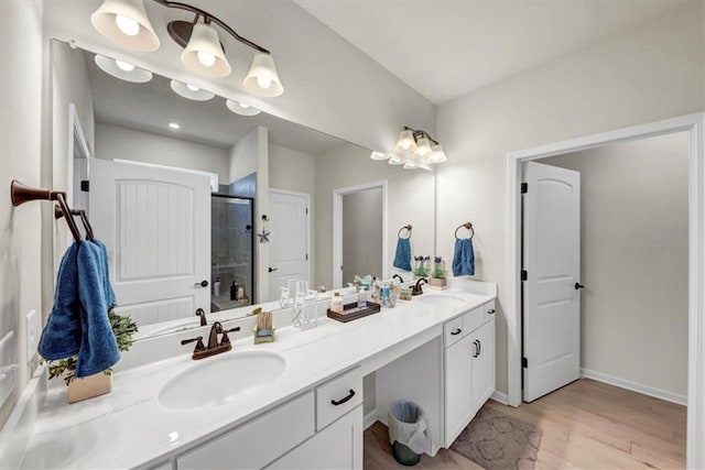 bathroom with vanity, hardwood / wood-style floors, and a shower with shower door