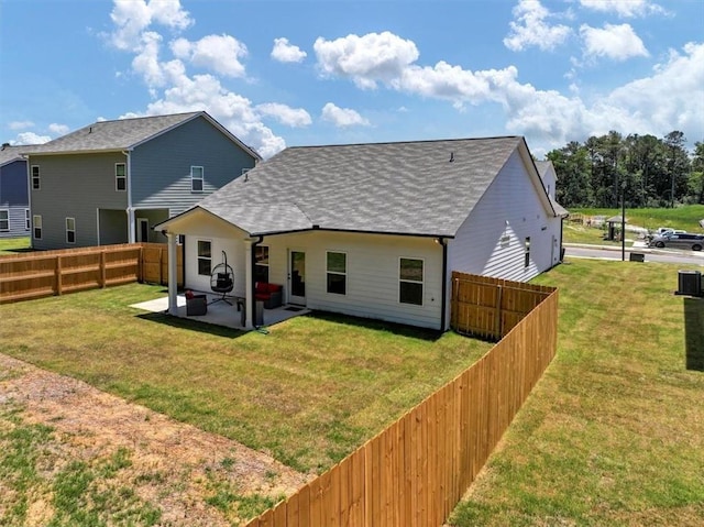 back of house with a patio and a lawn