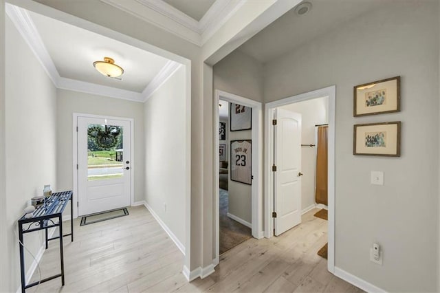 entryway with crown molding and light wood-type flooring