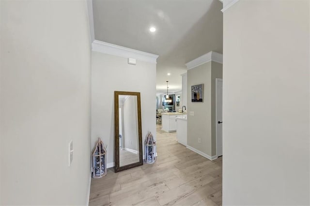 corridor featuring ornamental molding and light hardwood / wood-style floors