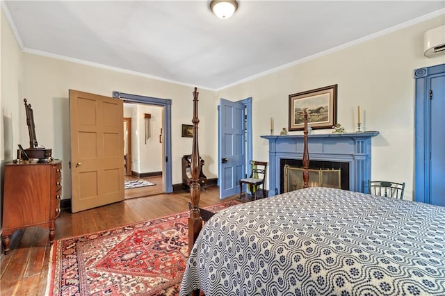 bedroom featuring dark hardwood / wood-style floors, crown molding, and a wall mounted air conditioner