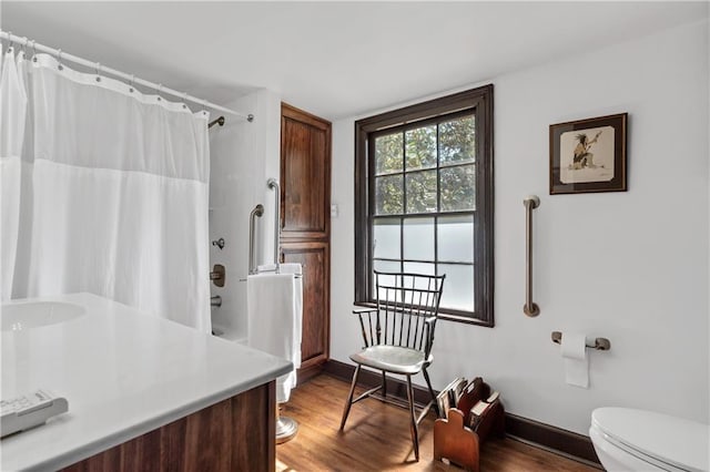 bathroom with walk in shower, hardwood / wood-style floors, vanity, and toilet