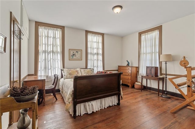 bedroom with multiple windows and wood-type flooring