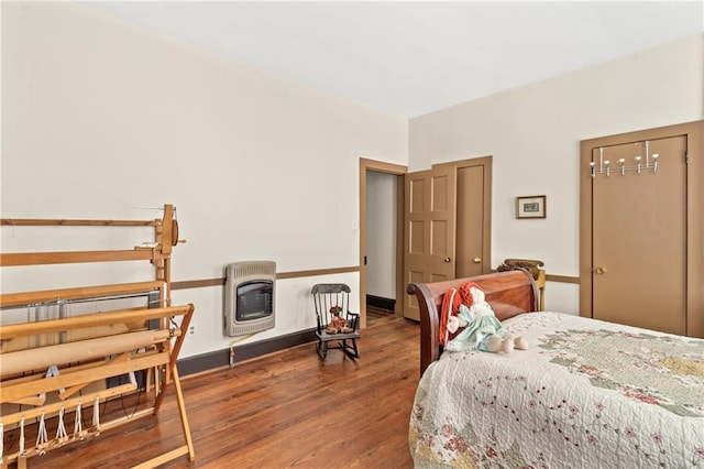 bedroom with dark wood-type flooring and heating unit