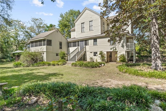 back of property with a yard and a sunroom