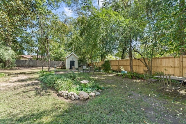 view of yard with an outdoor fire pit and a storage unit