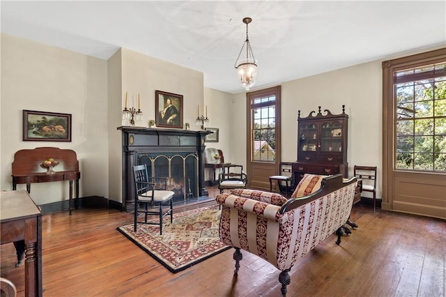 sitting room with plenty of natural light, hardwood / wood-style floors, and a chandelier