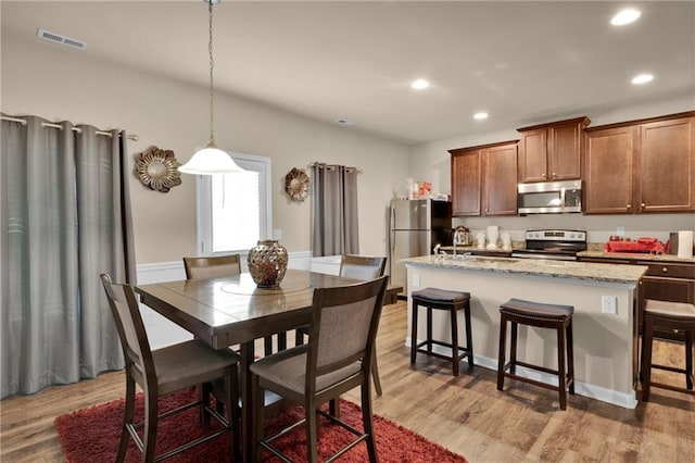 dining space with light hardwood / wood-style floors