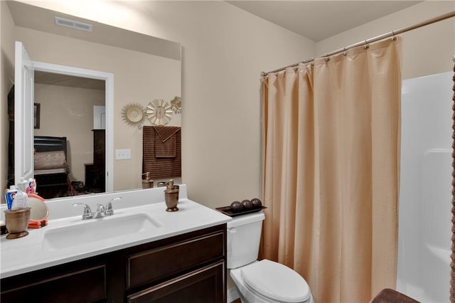 bathroom featuring curtained shower, toilet, and vanity