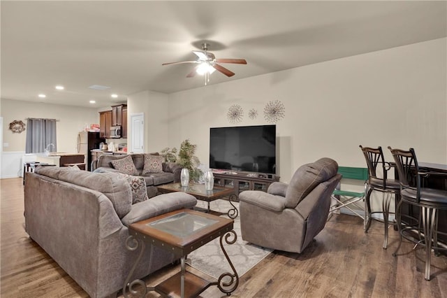 living room featuring wood-type flooring and ceiling fan