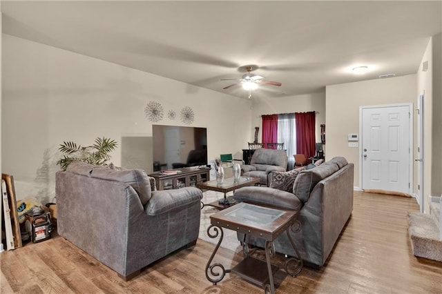 living room featuring light wood-type flooring and ceiling fan