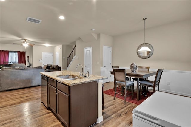 kitchen featuring light wood-type flooring, ceiling fan, sink, dark brown cabinets, and pendant lighting