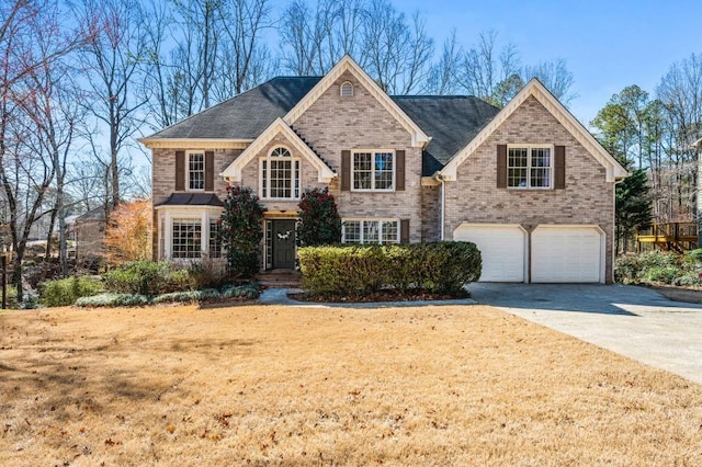 view of front of home with a garage, brick siding, and driveway