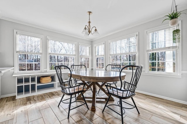 dining area featuring a chandelier, baseboards, wood finished floors, and crown molding