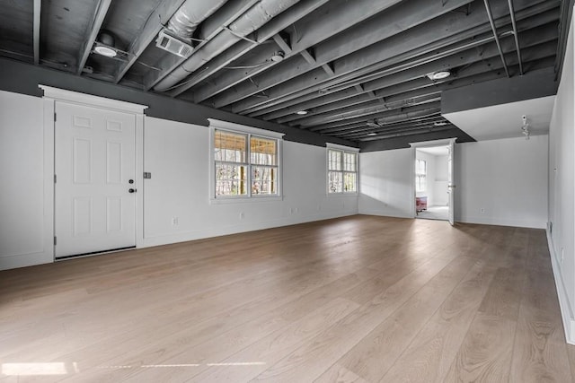 interior space featuring baseboards, visible vents, and light wood finished floors