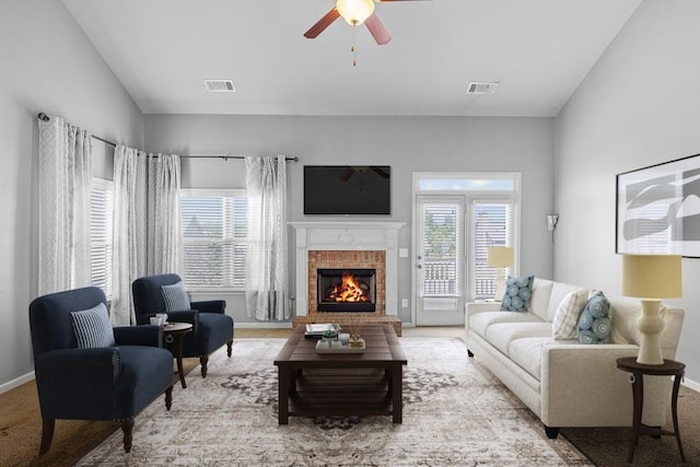 living room with light colored carpet, a brick fireplace, and ceiling fan