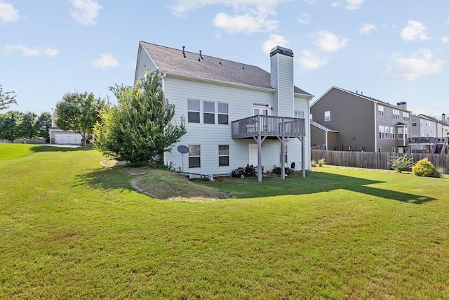 rear view of house with a wooden deck and a yard