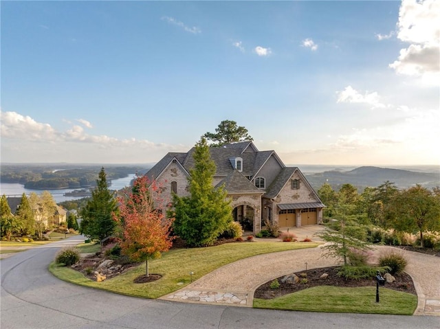 view of front of home featuring a yard, a garage, and a water view