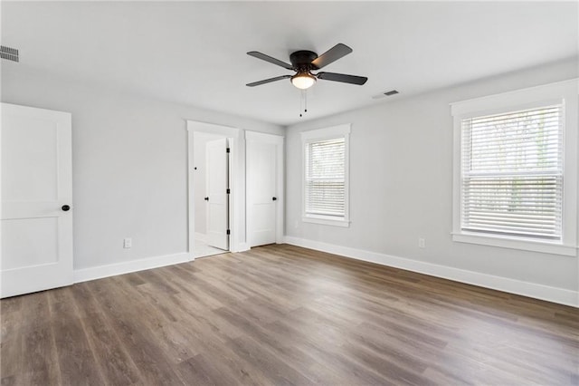 unfurnished bedroom with wood finished floors, visible vents, and baseboards