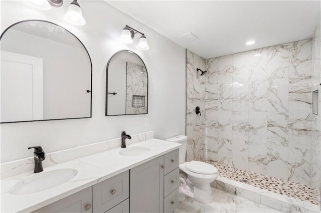 full bathroom with double vanity, marble finish floor, a shower stall, and a sink