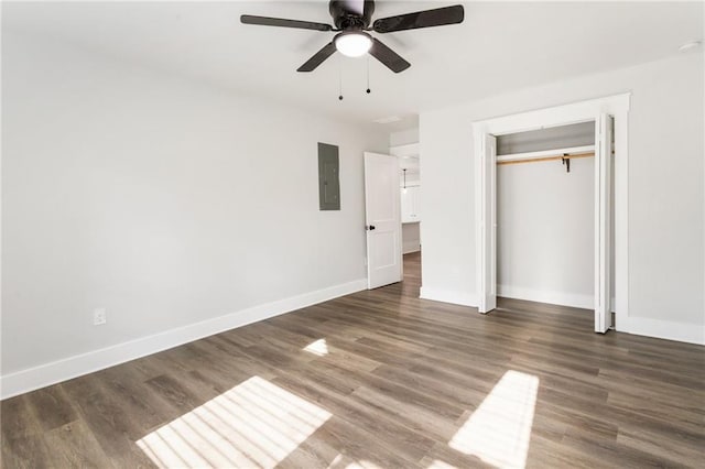 unfurnished bedroom featuring dark wood finished floors, electric panel, and baseboards