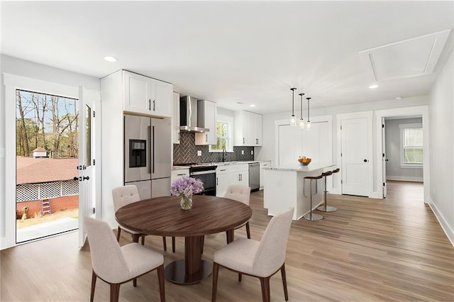 dining space with recessed lighting, baseboards, and light wood finished floors