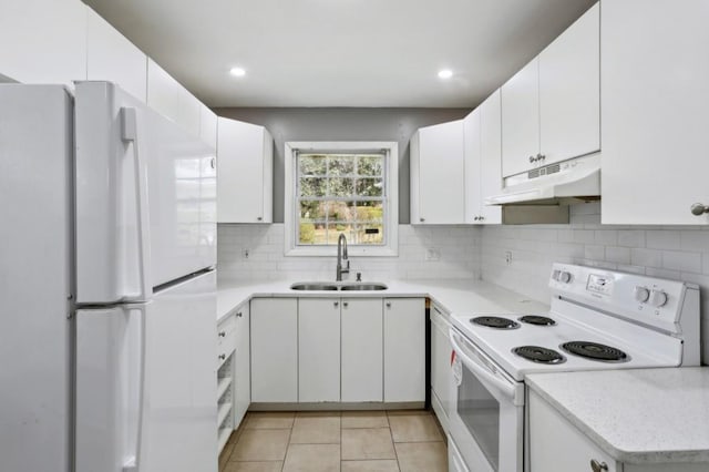 kitchen with tasteful backsplash, under cabinet range hood, light tile patterned floors, white appliances, and a sink