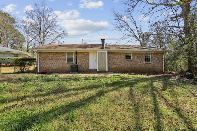 back of property with fence, a yard, cooling unit, brick siding, and a patio area