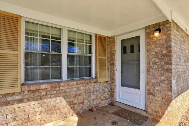 doorway to property with brick siding