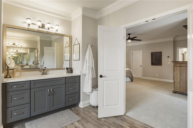 bathroom featuring crown molding, wood-type flooring, vanity, and ceiling fan