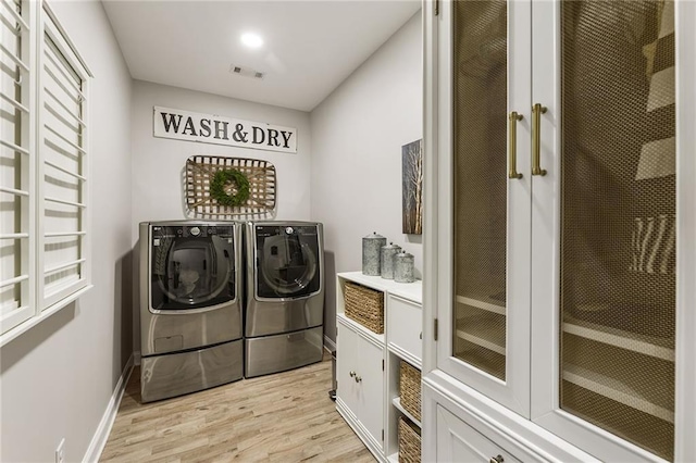 laundry room featuring separate washer and dryer and light wood-type flooring