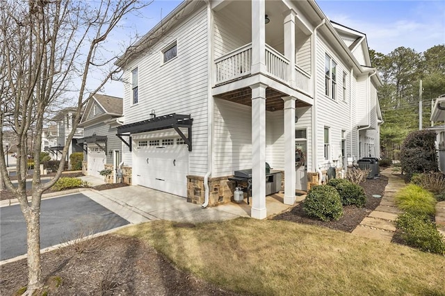 view of property exterior with central AC, a garage, a balcony, a yard, and a pergola