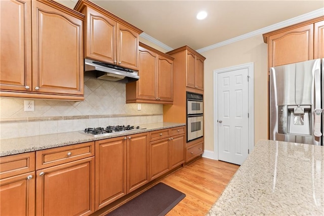 kitchen with light stone countertops, light hardwood / wood-style floors, crown molding, and appliances with stainless steel finishes