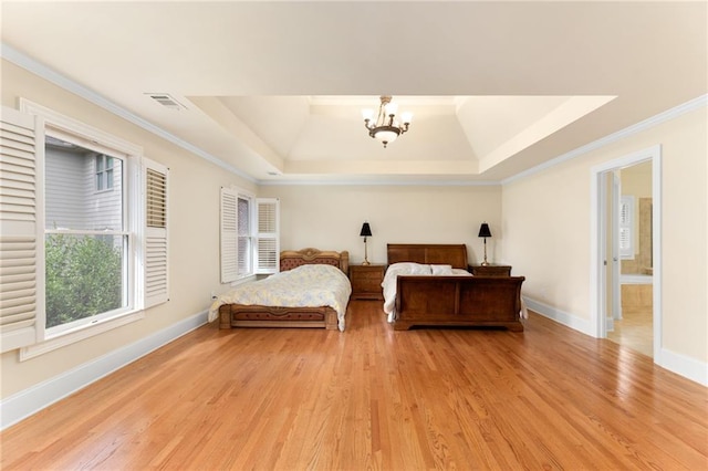 bedroom featuring a notable chandelier, light hardwood / wood-style flooring, crown molding, and a tray ceiling