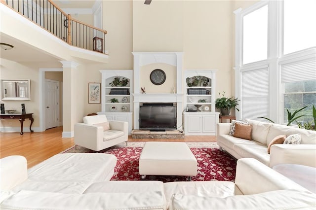 living room with hardwood / wood-style floors and a towering ceiling