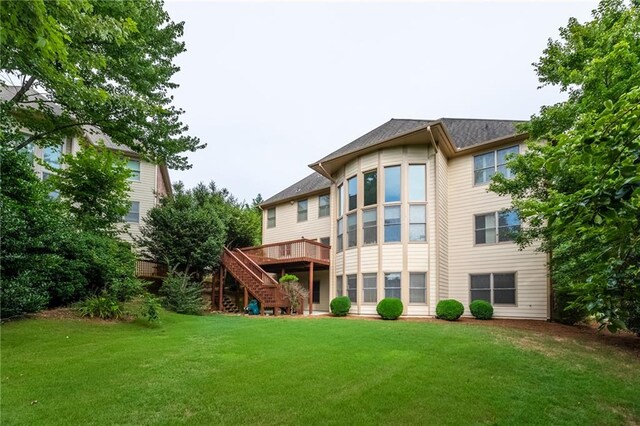 back of house featuring a wooden deck and a lawn