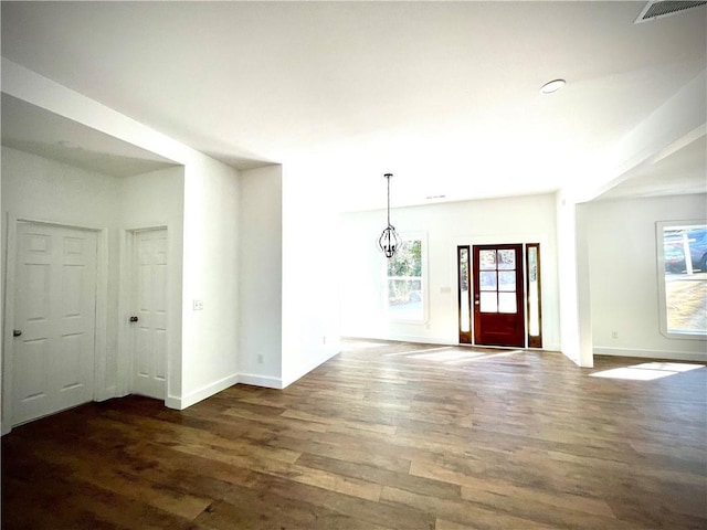 foyer entrance featuring baseboards, visible vents, and dark wood-type flooring